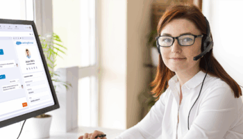 conseillère centre de contacts devant ordinateur, travaille avec son logiciel CRC et son CRM connectés