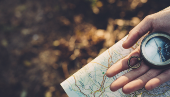 Main tenant une boussole sur une carte illustrant la stratégie de relation client 2026